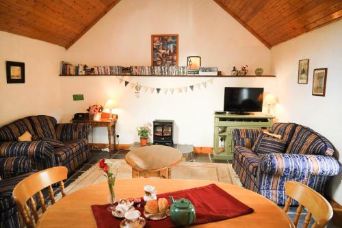 百利科内尔Wisteria Cottage的带沙发、桌子和电视的客厅