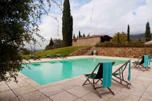 基安蒂格雷夫Villa Rosano的一个带两把椅子的游泳池以及一座房子