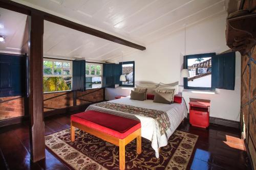 帕拉蒂巴托洛梅乌旅馆的一间卧室配有一张带红色长凳和窗户的床。