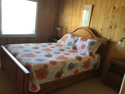 特里尼蒂三一套房公寓的一间卧室配有一张带花卉棉被的床