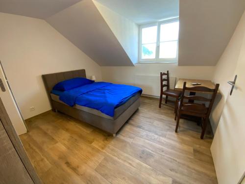 KleinlützelHotel Gasthof Engel的卧室配有一张床和一张桌子及椅子