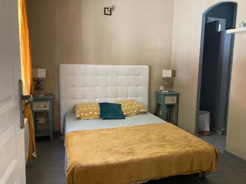 博尼法乔Petite maison de campagne的一间小卧室,配有一张带两张桌子的床