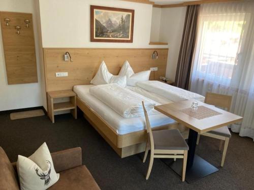 塞尔瓦迪加尔代纳山谷Garni Flurida的酒店客房设有一张大床和一张桌子。