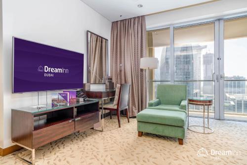 迪拜Dream Inn Apartments - Premium Apartments Connected to Dubai Mall的酒店的客房配有电视、椅子和书桌
