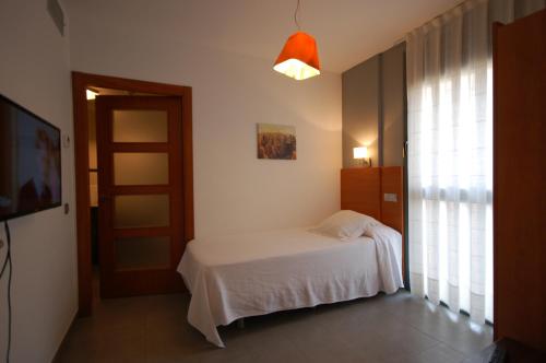 锡切斯锡切斯度假公寓的卧室配有白色的床和窗户。