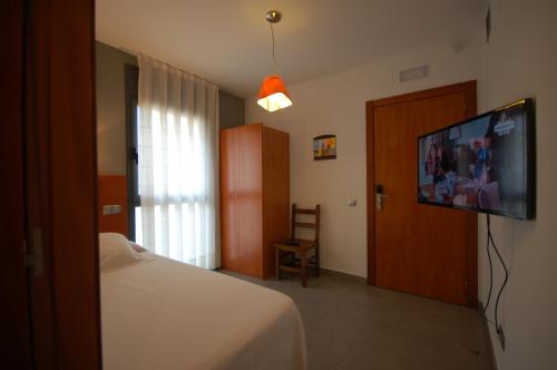 锡切斯塞特格斯公寓酒店的一间卧室配有一张床和一台平面电视