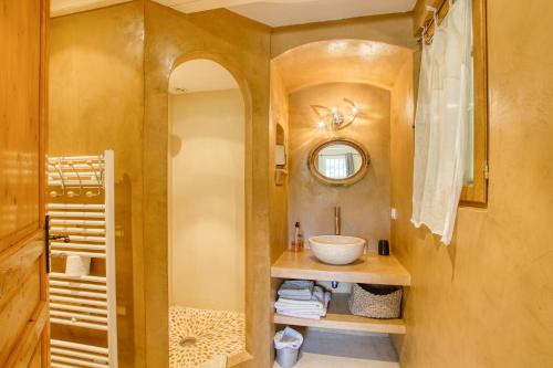 拉卡迪埃达聚Le Mas de la Noria的一间带水槽和镜子的浴室