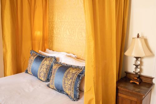 Eaglesfield斯普林克尔旅馆的一间卧室配有一张带黄色窗帘和灯的床