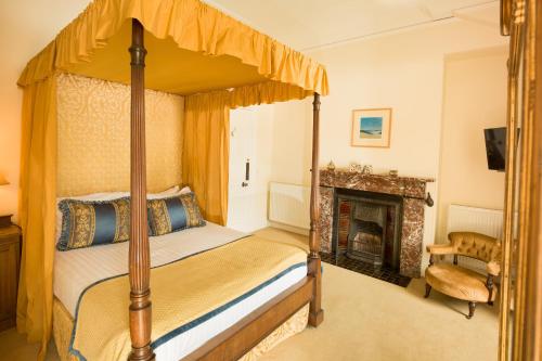 Eaglesfield斯普林克尔旅馆的一间卧室设有四柱床和一个壁炉