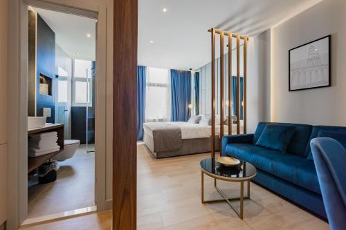 斯普利特Caldo Luxury Rooms的一间带蓝色沙发的客厅和一间卧室