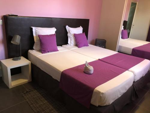 圣弗朗索瓦Villa Natur Dylis的一间卧室配有两张带紫色和白色枕头的床