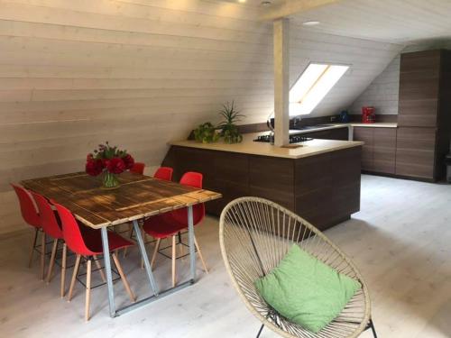 科尔马Gîtes du Tichweg的厨房配有木桌和红色椅子
