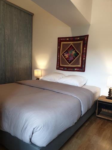 Verneuil-le-ChâteauLa Tour du Raygnier的卧室配有一张大床,墙上挂着地毯