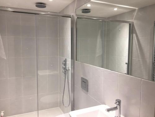 伦敦Central London Charming Camden Split Level Home的带淋浴、盥洗盆和镜子的浴室