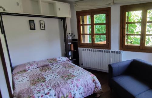 贝纳斯克La Solana del Laball的一间卧室配有一张床和一把椅子,还有两个窗户