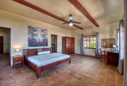 南圣胡安La Veranera, Playa El Coco的一间卧室配有一张床和吊扇