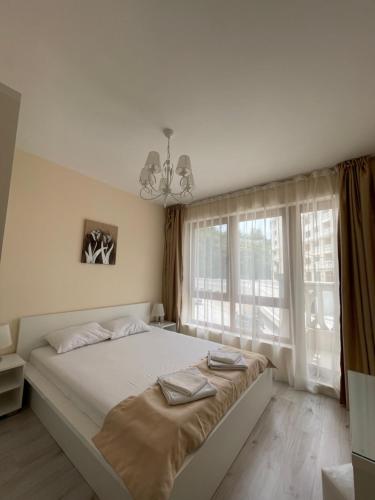 瓦尔纳Deluxe Apartment Varna South Bay Beach Residence的一间卧室设有一张大床和一个大窗户
