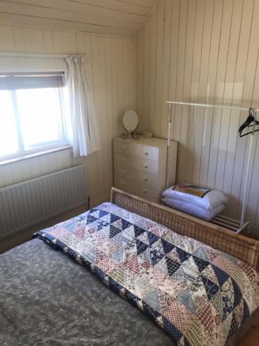 KilmoreMo's Cottage的一间卧室配有一张床、一个梳妆台和一扇窗户。