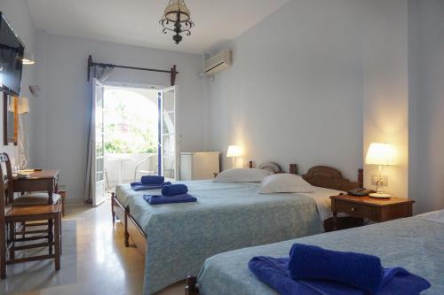 卡马利国花酒店 的一间卧室配有两张床和蓝色毛巾。