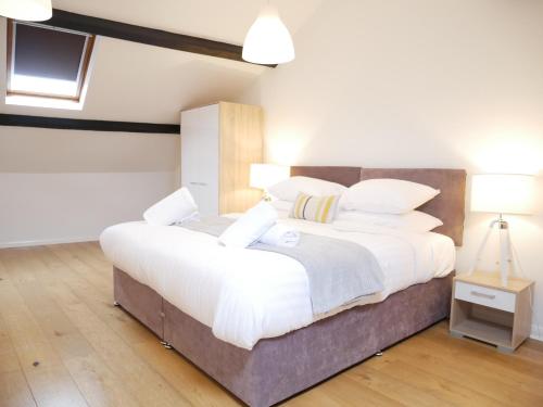 阿尔弗斯顿Nordic Suites Apartment, Ulverston的卧室配有一张带白色床单和枕头的大床。