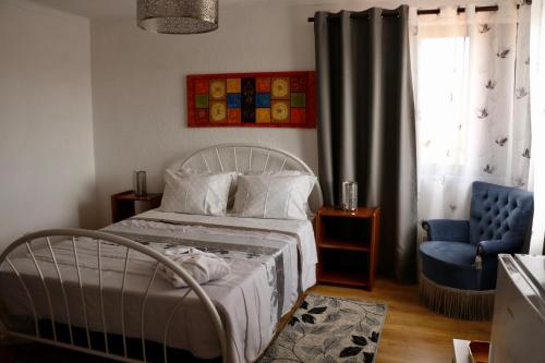 塞辛布拉卡萨特瑞斯哈住宿加早餐旅馆的一间卧室配有一张床和一张蓝色椅子