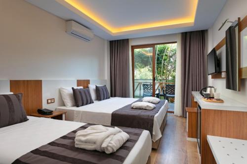 特基罗瓦Le Marden Hotel Spa的酒店客房设有两张床和一个阳台。