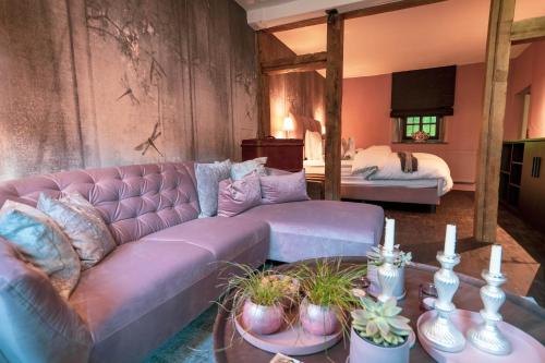 PilligLÖFFELMÜHLE BOUTIQUE BED AND BREAKFAST的客厅配有紫色沙发和床。