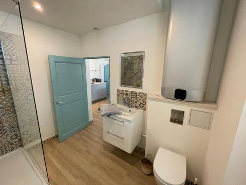 洛尔格Carnets de voyage Coté studios的一间带卫生间和玻璃淋浴间的浴室
