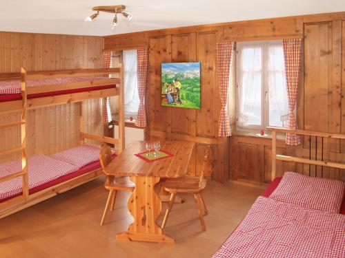 RuscheinBoardercamp Laax - swiss mountain hostel的客房设有一张桌子和两张双层床。