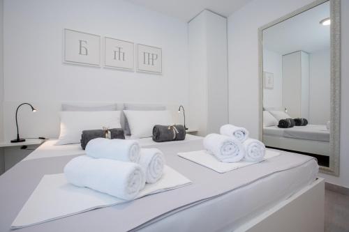 拉布Sunny Apartments Rab的一张带毛巾的白色床和镜子