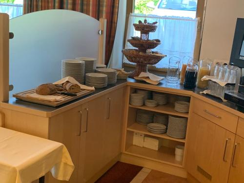 涅德劳Hotel Schneeberger的厨房配有带盘子和餐具的柜台