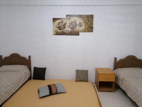 海尔盖莱Hergla_AFH_Beach的一间卧室配有两张床和一张带枕头的桌子