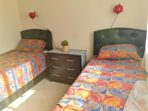 布兹尼盖Residence ocean的一间卧室配有两张床、一个梳妆台和床头柜。