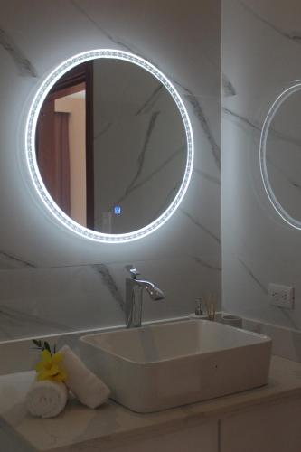塔马林多Casa Coco de Mer 1的一间带水槽和圆镜子的浴室