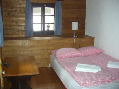 索内纳尔佩·纳斯费尔德哈恩公寓的一间卧室配有一张带桌子和窗户的床