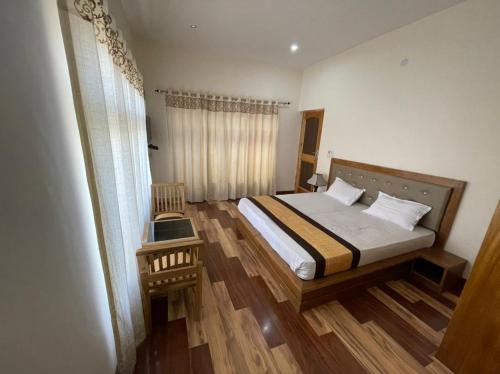 列城HOTEL KHARDONGLA的一间卧室配有一张床,铺有木地板
