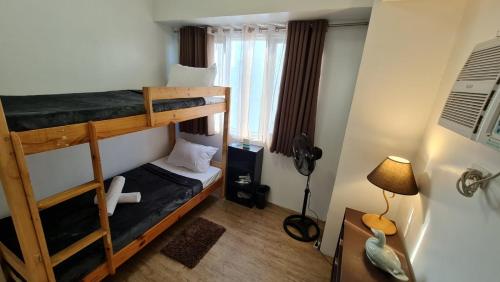 马尼拉Sea Residences - Condo R Us的一间卧室配有两张双层床和一盏灯。