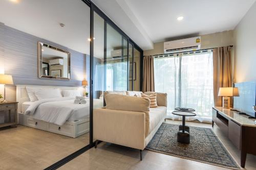 华欣la Casita Hua Hin by J&P的一间卧室配有一张床、一把椅子和镜子