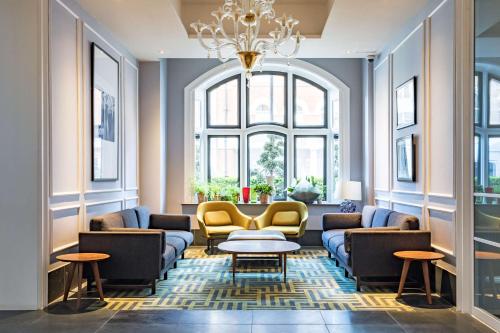 伦敦Radisson Blu Hotel, London Bloomsbury的带沙发和桌子的客厅以及吊灯。