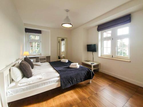 尤斯托尼莫斯基Apartamenty Stella Mare - 365PAM的卧室配有白色的床和2扇窗户。