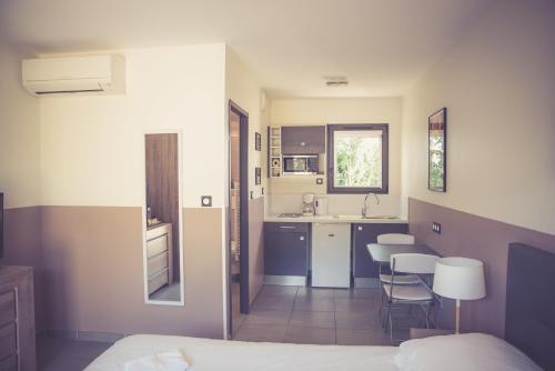卡尔卡松514公寓酒店的一间卧室配有一张床,厨房配有椅子