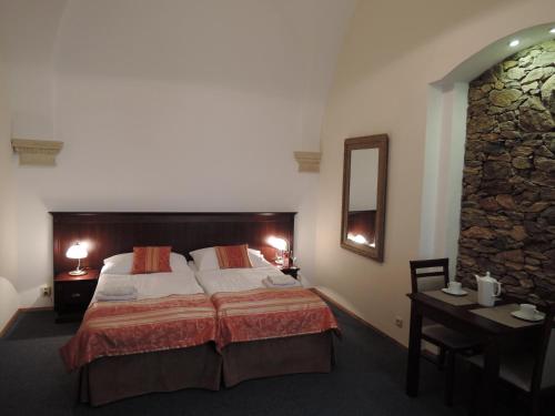 兹诺伊莫乌希萨尔兹蒙大旅馆的一间卧室配有一张床、一张桌子和一面镜子