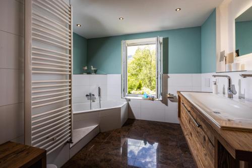 马克特谢伦贝格Landurlaub Hinterbrandner的带浴缸、水槽和窗户的浴室