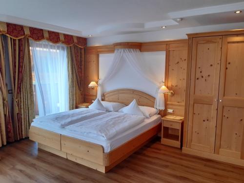 塞尔瓦迪加尔代纳山谷Garni Hotel Franca b&b的一间卧室配有一张带天蓬的大床