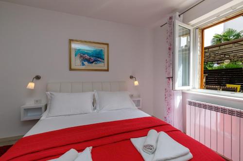 波雷奇Apartments Lavizatic的卧室设有红色和白色的床和窗户。