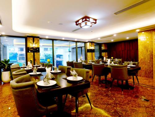 河江Silk River Hotel Ha Giang的一间在房间内配有桌椅的餐厅