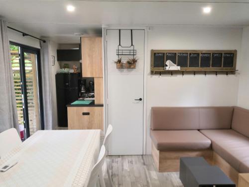 比斯卡罗斯Mobil Home Camping Mayotte Biscarrosse的带沙发的小客厅和厨房