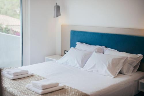 卡拉马孔Corner45 Apartments的一张白色的床,上面有两条毛巾