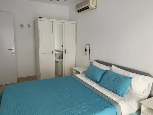 阿尔梅利马Apartamento Aguamarina的一间卧室配有一张带蓝色和白色枕头的床
