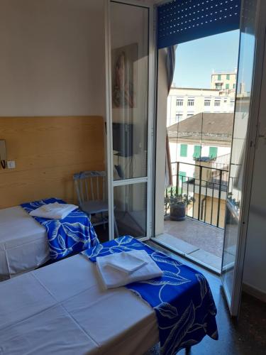 热那亚Hotel Guesthouse MASSENA的一间卧室设有两张床和大窗户